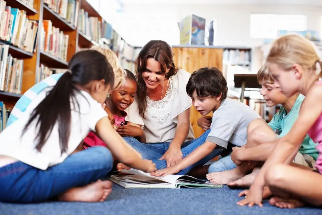 Teacher and Students reading on library floor