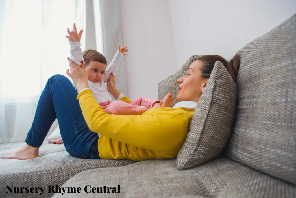 mother raising the hands of her baby