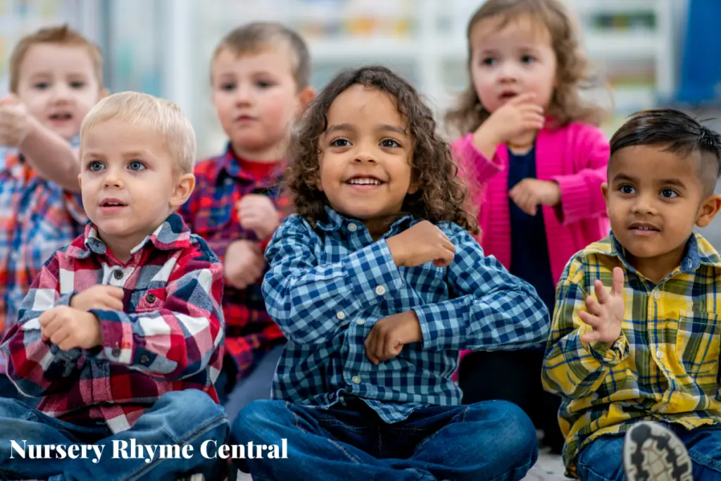 6 children rolling arms around sitting in a classroom singing nursery rhymes